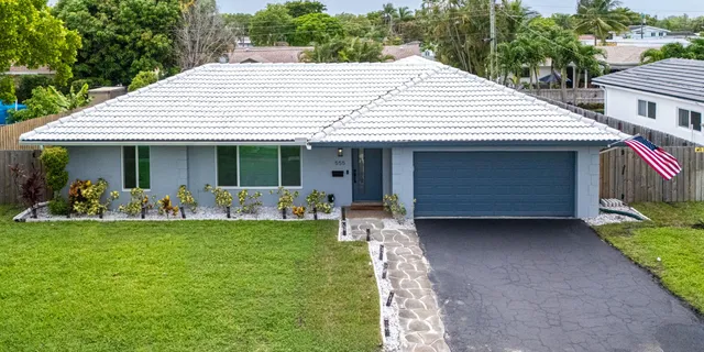 a front view of a house with a garden and plants