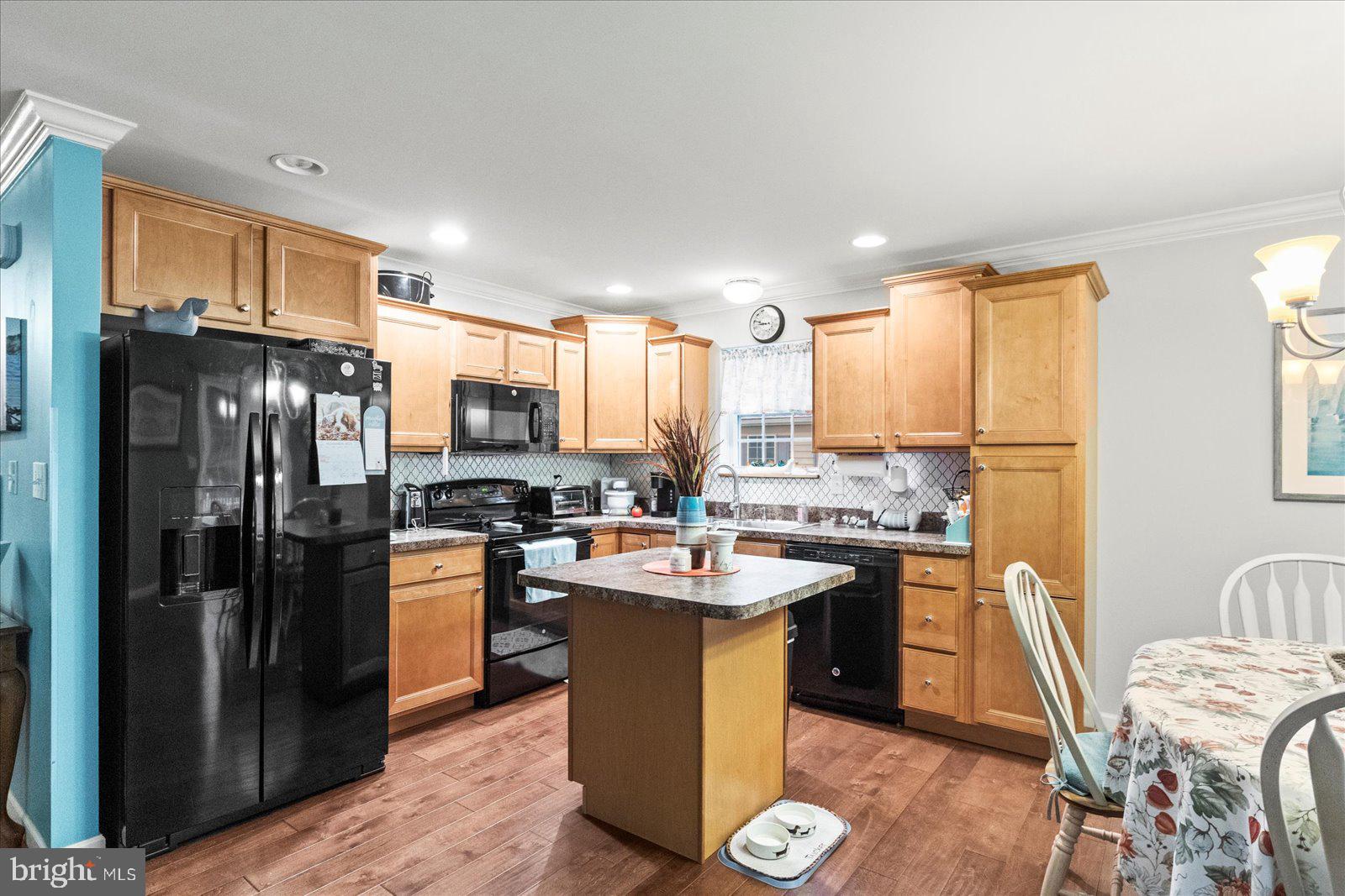 555 Countryside Road Seven Valleys, PA 17360 - Photo 15 of 56 a kitchen with a sink a kitchen island stainless steel appliances cabinets and a counter top space