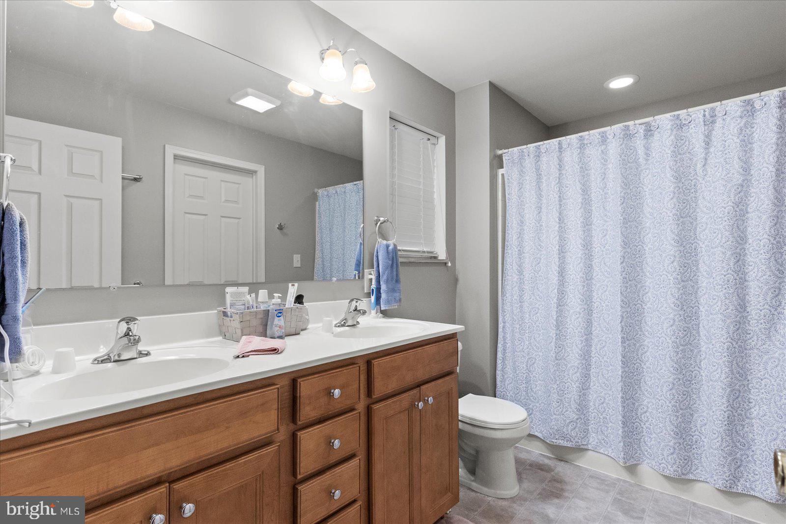 555 Countryside Road Seven Valleys, PA 17360 - Photo 23 of 56 a bathroom with a double vanity sink toilet and a mirror