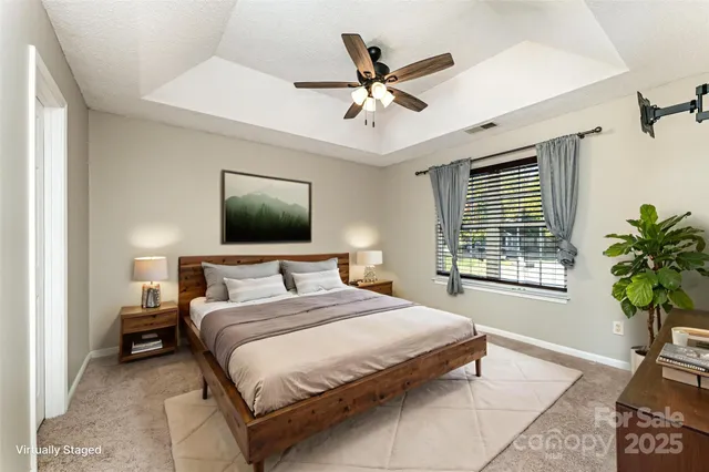 a bedroom with a large bed and a chandelier