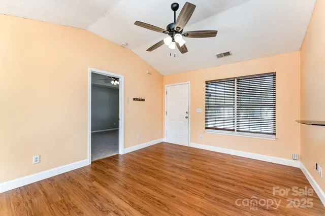 a view of an empty room with a window and a ceiling fan