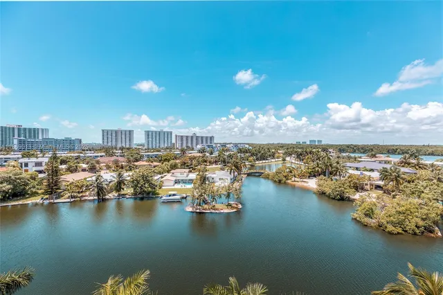 an aerial view of ocean and residential houses with outdoor space