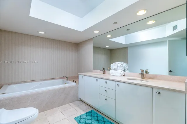 a bathroom with a granite countertop sink a toilet and bathtub