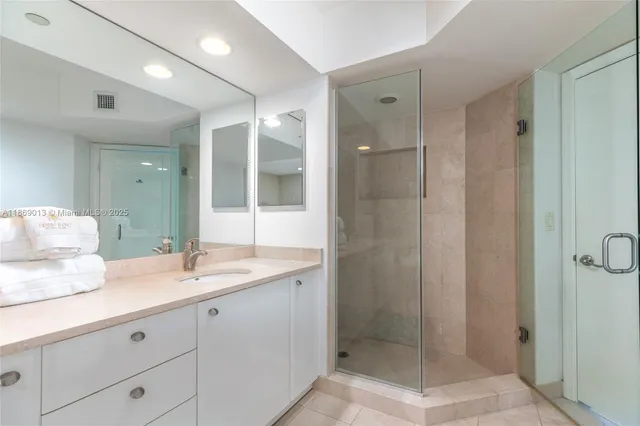 a bathroom with a shower sink and mirror