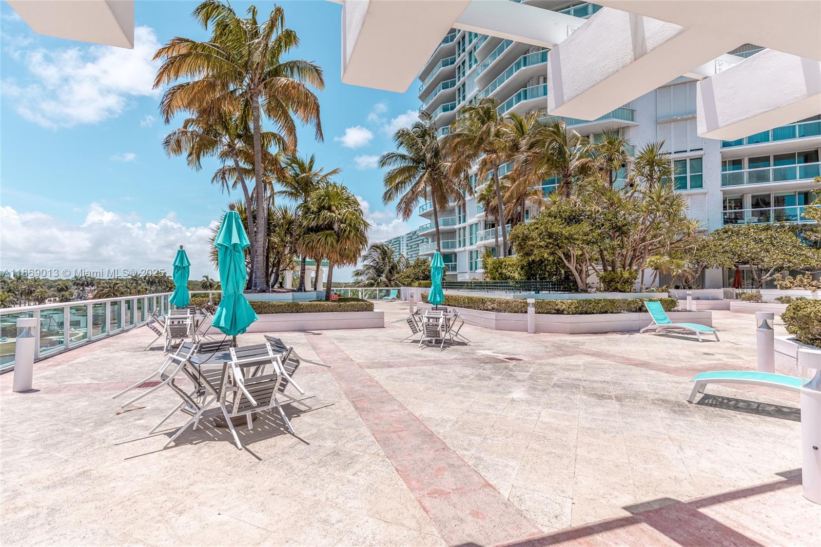 16500 Collins Avenue, Unit 655 Sunny Isles Beach, FL 33160 - Photo 37 of 48 a view of a swimming pool with a lounge chair and palm trees