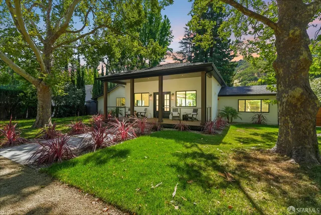 a view of a chair and table in backyard of the house