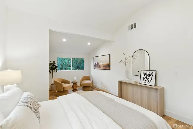 a view of a bedroom with a bed and wooden floor