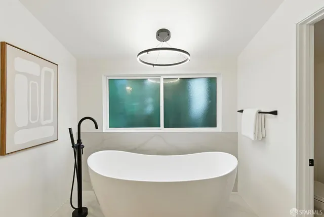 a bathroom with a bathtub and a window