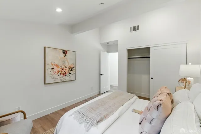 a bedroom with a bed and a painting on the wall