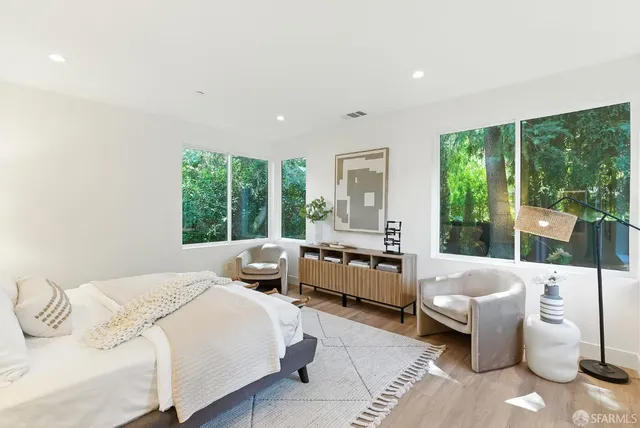 a bedroom with a bed and large windows