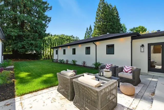 a view of backyard of house with outdoor seating