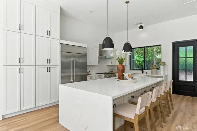 a kitchen with kitchen island a stove a sink and a wooden floor