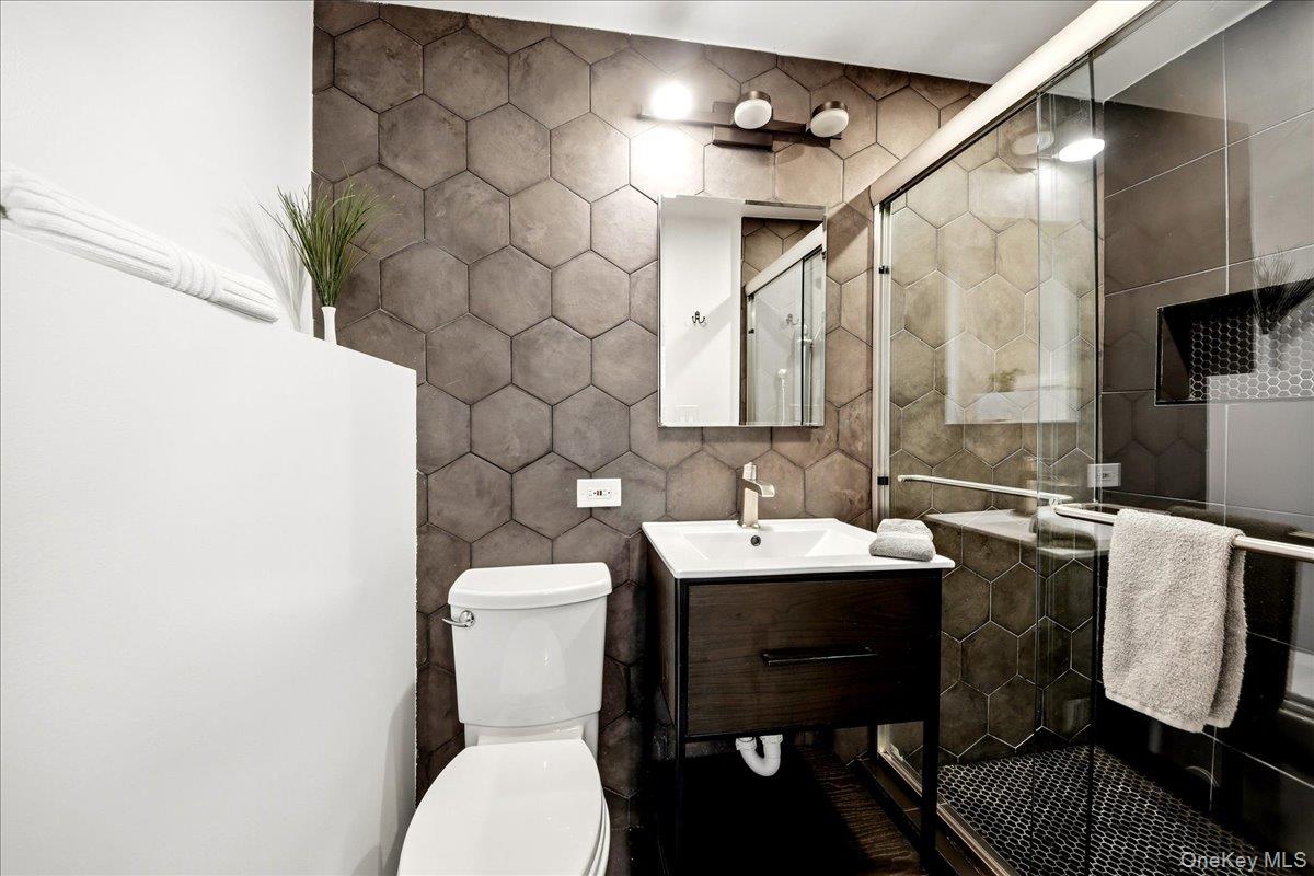 93 Fordham Street Bronx, NY 10464 - Photo 28 of 41 a bathroom with a toilet sink vanity and mirror