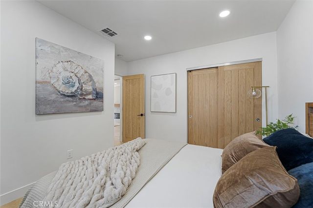 a bedroom with a large bed and a painting on the wall