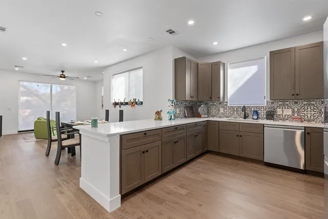 a kitchen with stainless steel appliances white cabinets and a stove top oven