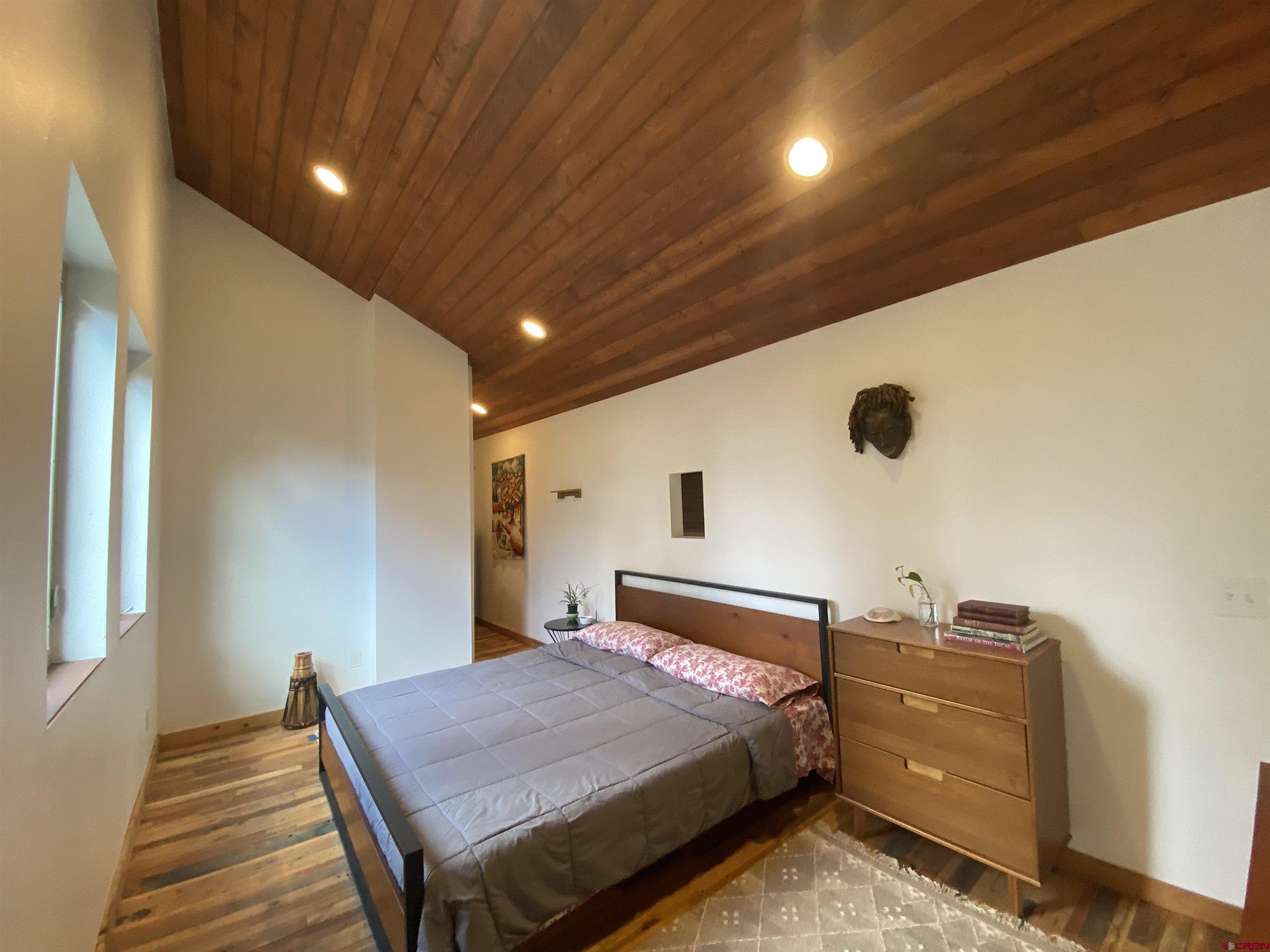 593 Crest Drive Cimarron, CO 81220 - Photo 11 of 30 a bedroom with a bed and a chandelier