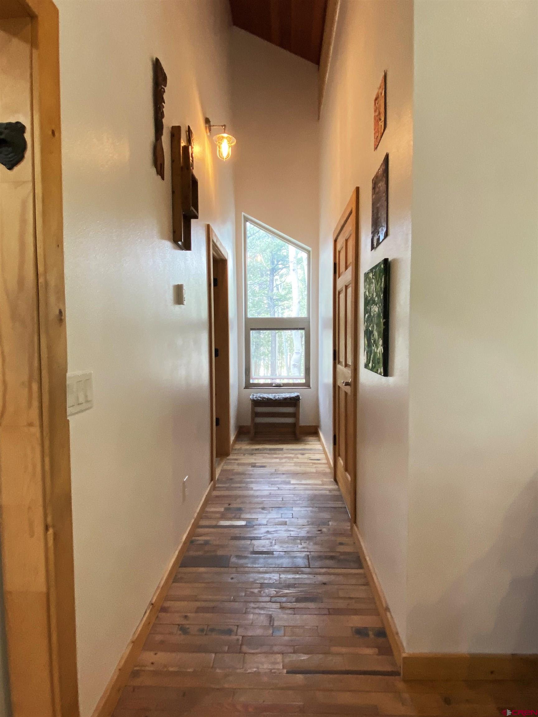 593 Crest Drive Cimarron, CO 81220 - Photo 4 of 30 a view of a hallway with wooden floor and windows