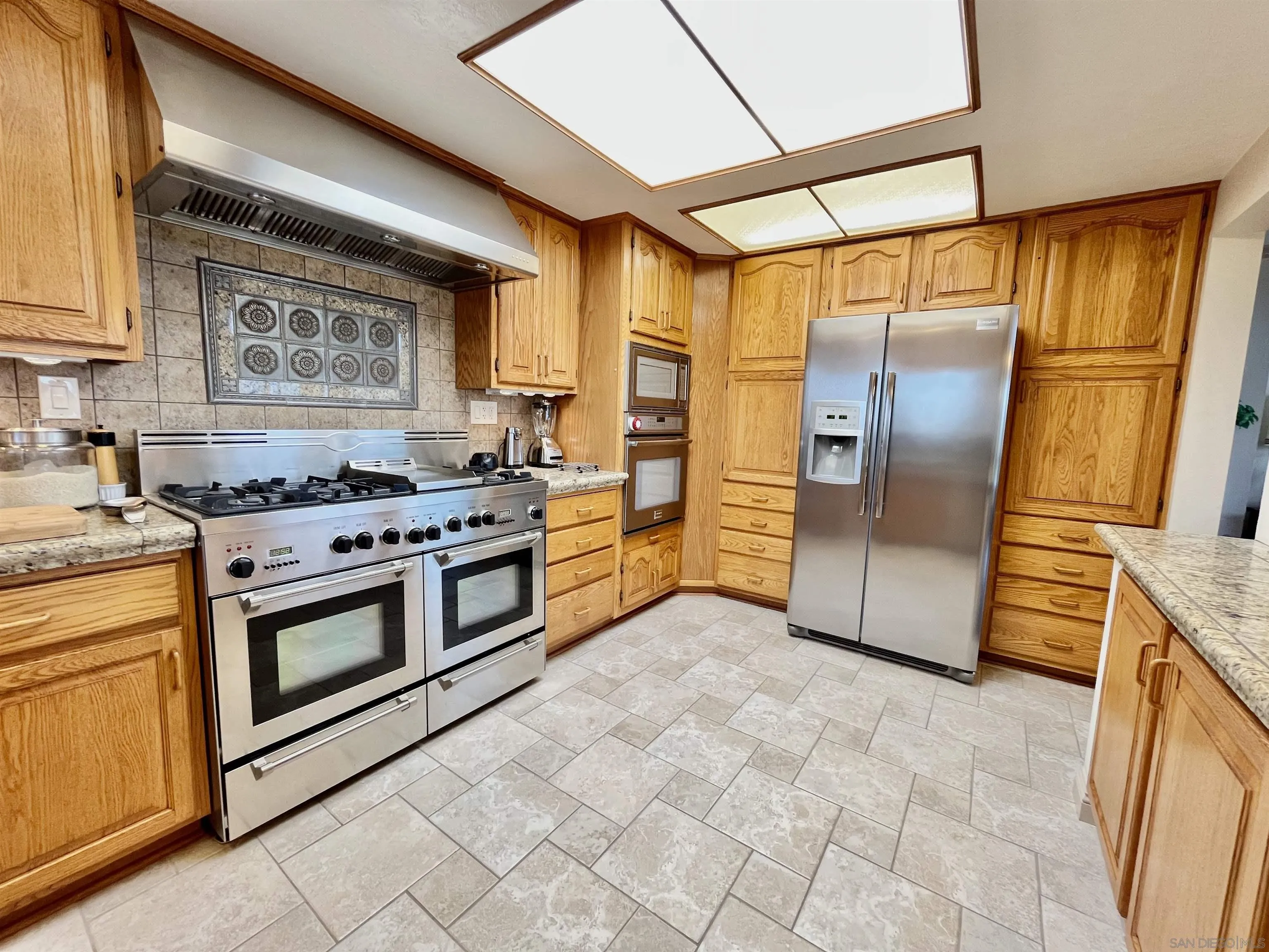 8844 Golf Drive Spring Valley, CA 91977 - Photo 12 of 56 a kitchen with stainless steel appliances granite countertop a stove a refrigerator and a cabinets