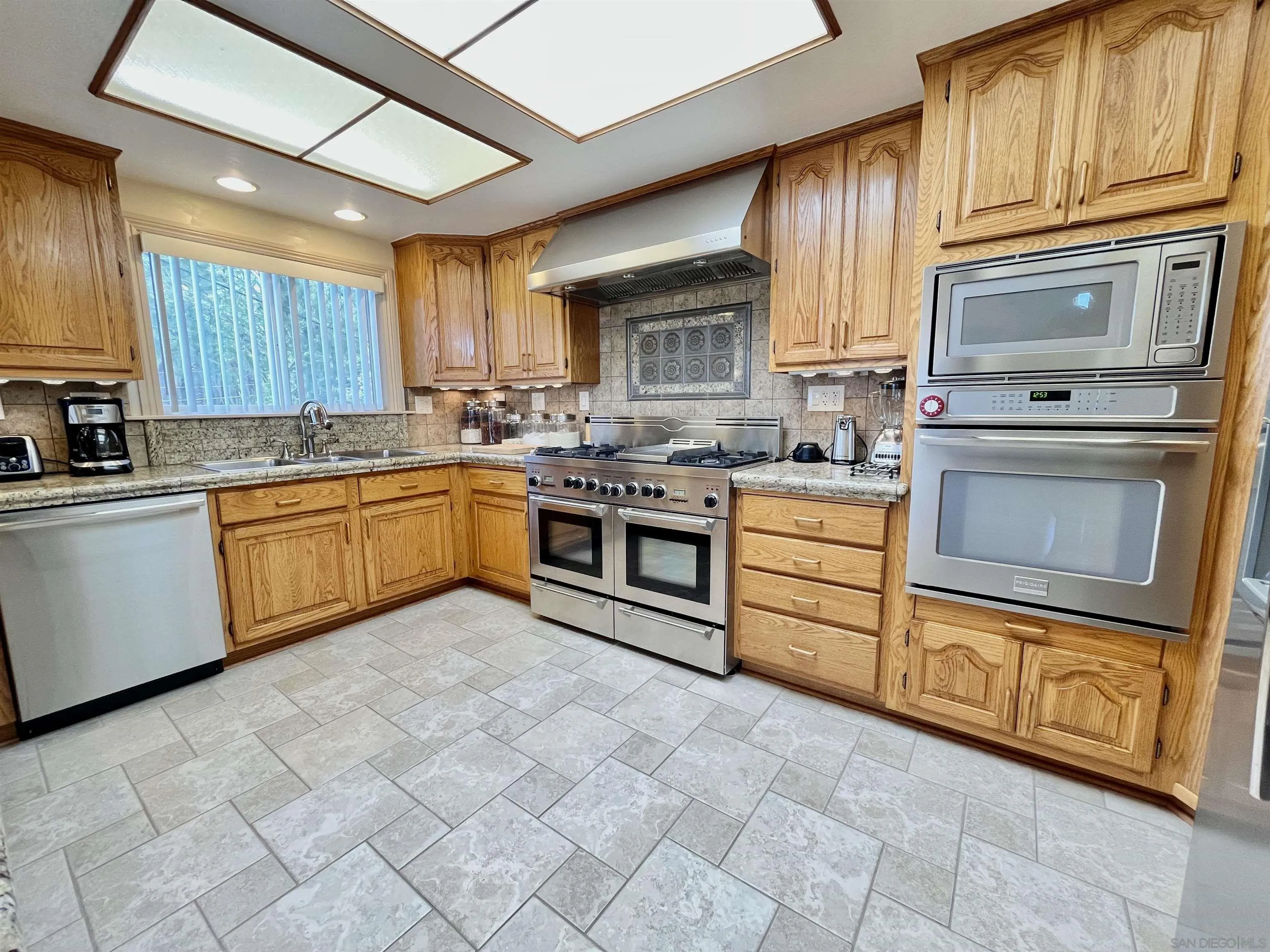 8844 Golf Drive Spring Valley, CA 91977 - Photo 13 of 56 a kitchen with stainless steel appliances granite countertop a stove sink and cabinets