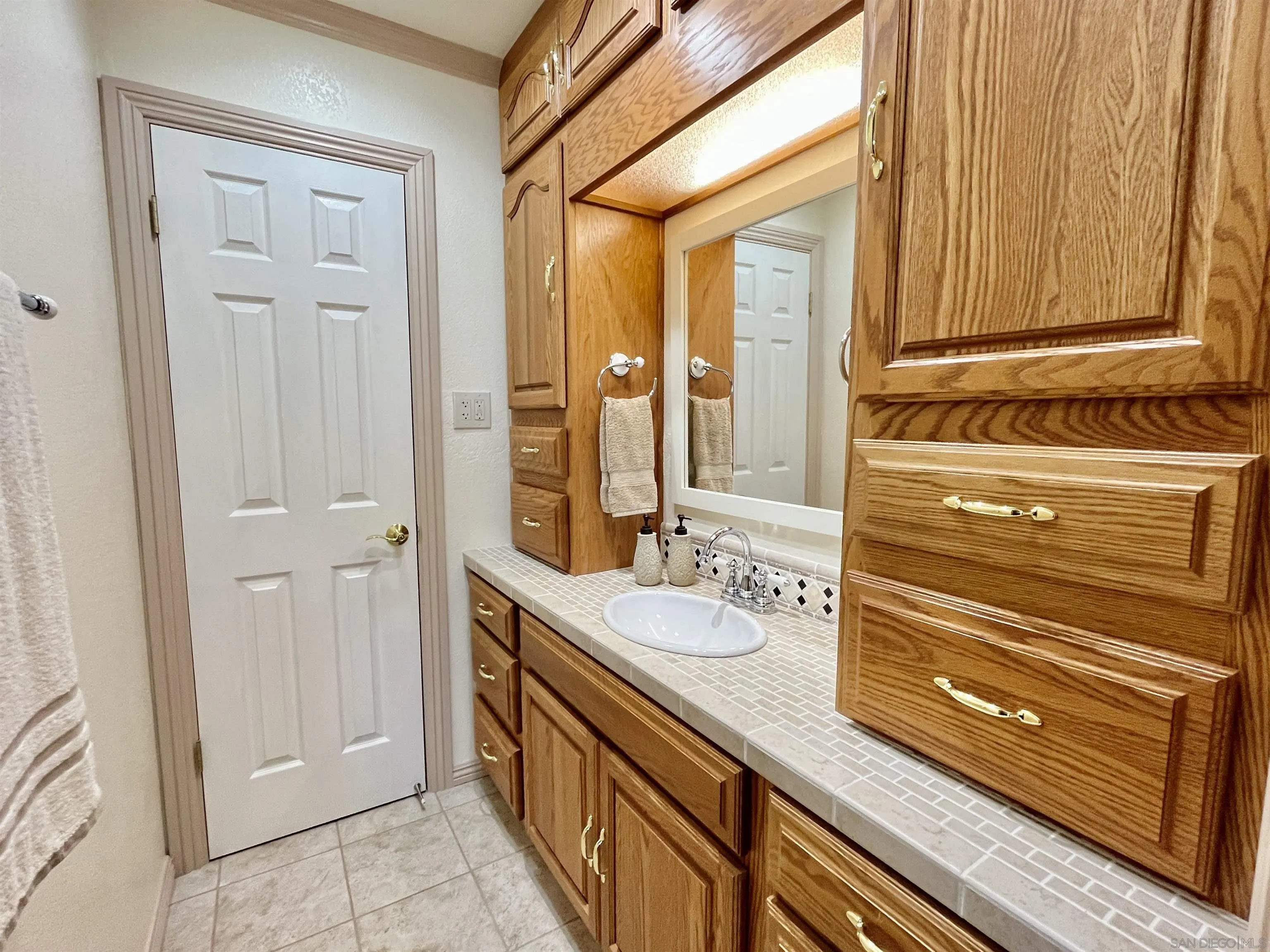 8844 Golf Drive Spring Valley, CA 91977 - Photo 20 of 56 a bathroom with a sink a mirror and a shower