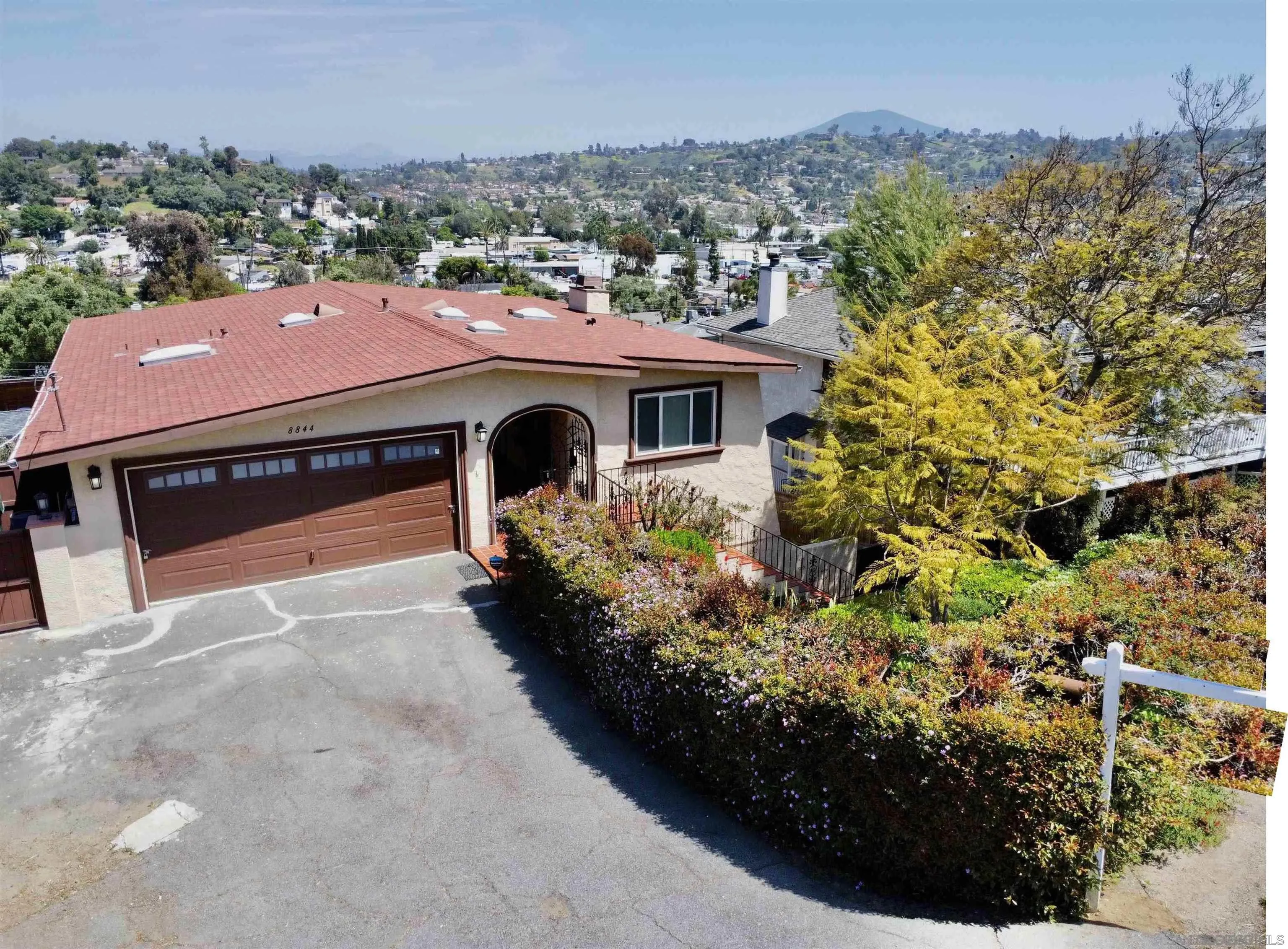 8844 Golf Drive Spring Valley, CA 91977 - Photo 3 of 56 a front view of a house with a yard and mountain view in back