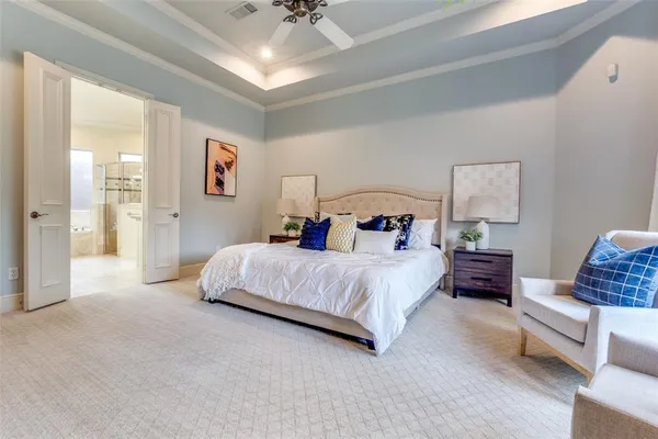 a spacious bedroom with a bed and a chandelier