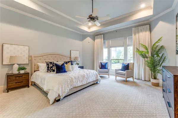 a bedroom with a bed couch and a large window