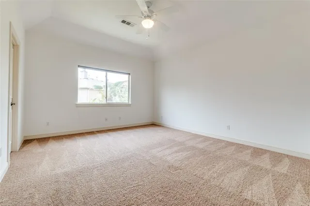 an empty room with a window and a ceiling fan