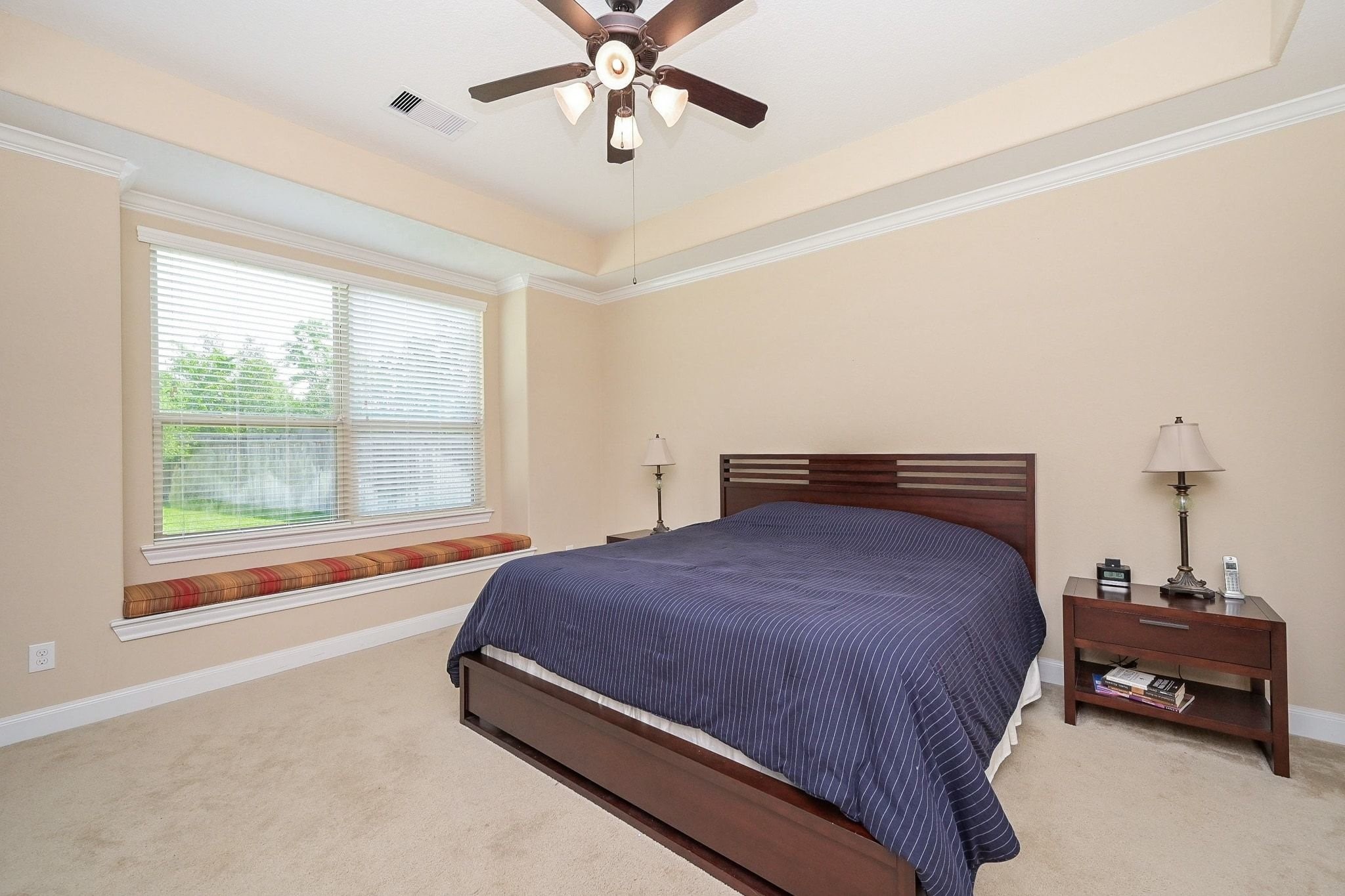107 North Bacopa Drive Spring, TX 77389 - Photo 22 of 34 Serene bedroom with a ceiling fan and large windows that fill the space with natural light, creating a peaceful and inviting atmosphere.