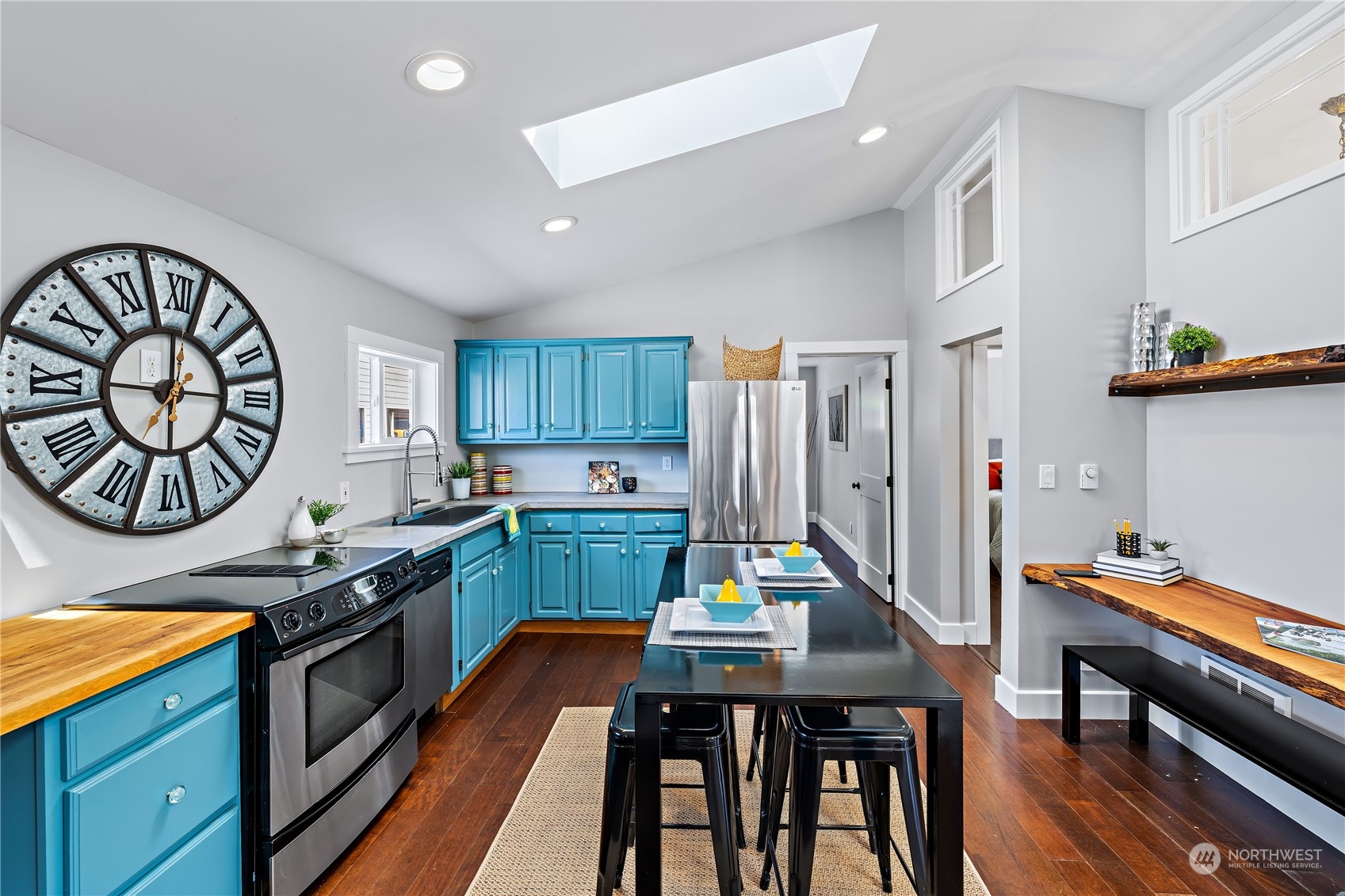 9012 7th Avenue Northwest Seattle, WA 98117 - Photo 12 of 36 a kitchen with stainless steel appliances granite countertop a stove a sink dishwasher and cabinets with wooden floor