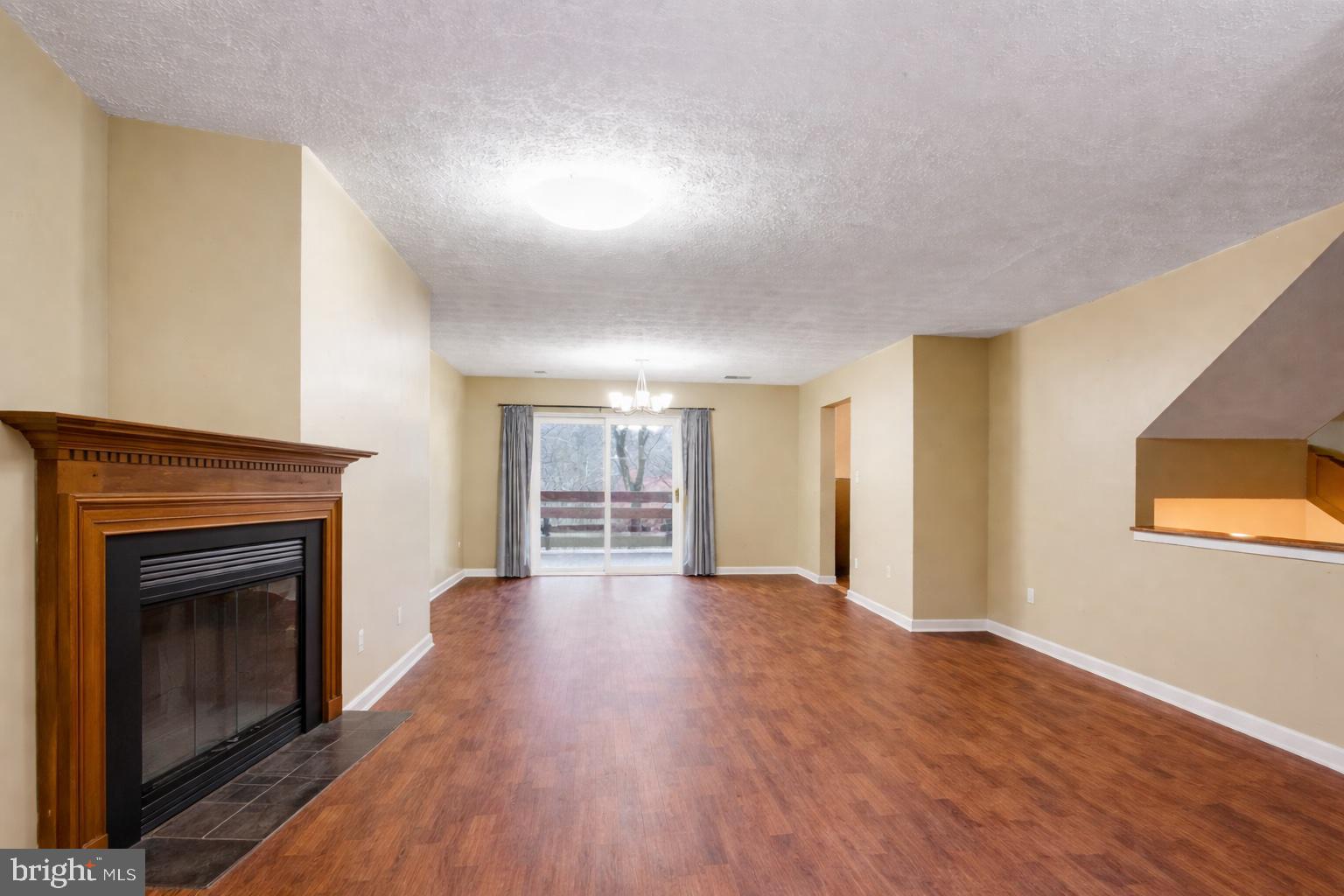 7579 Weather Worn Way, Unit D Columbia, MD 21046 - Photo 5 of 24 a view of empty room with wooden floor and fireplace