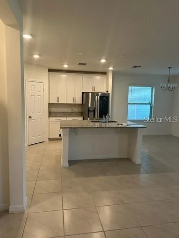 a large kitchen with kitchen island a sink stainless steel appliances and cabinets