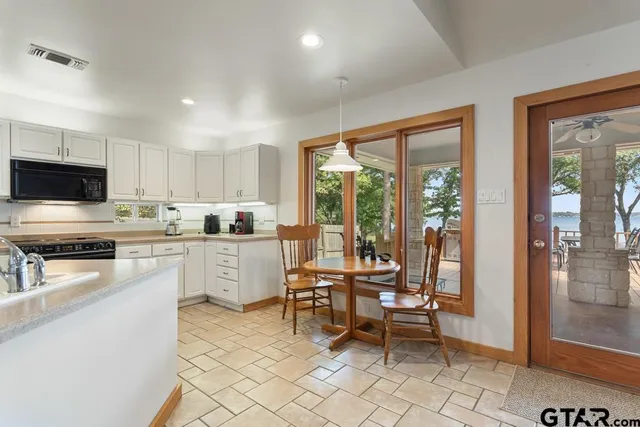 a kitchen with white cabinets and appliances
