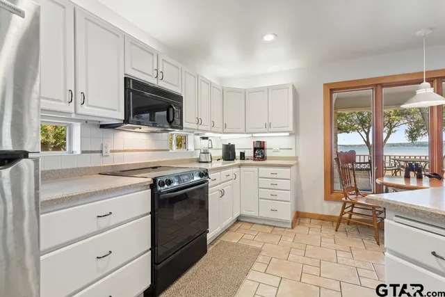 a view of kitchen with cabinets and appliances