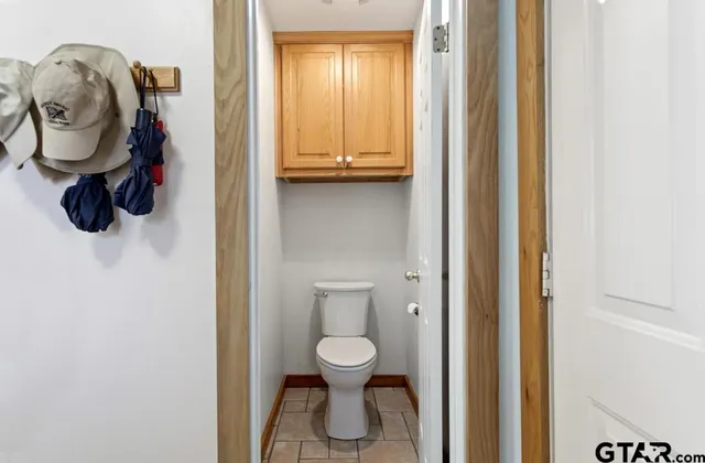 a bathroom with a toilet a sink a mirror and vanity