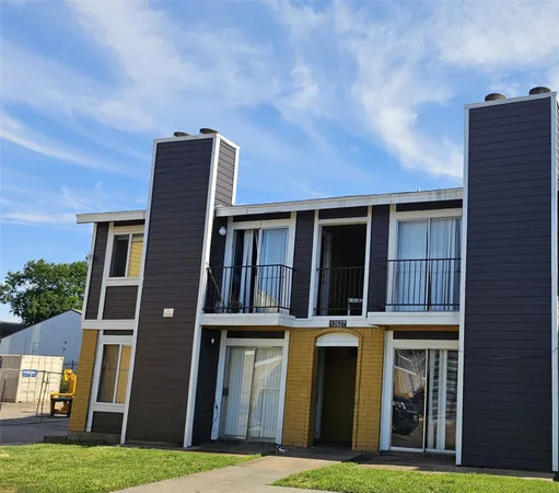 a tall brick building with a yard in front of it