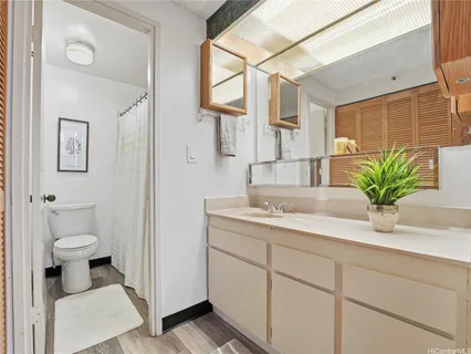 a bathroom with a granite countertop sink a toilet and a mirror