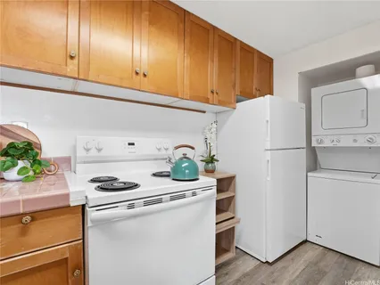a white refrigerator freezer and a stove sitting inside of a kitchen