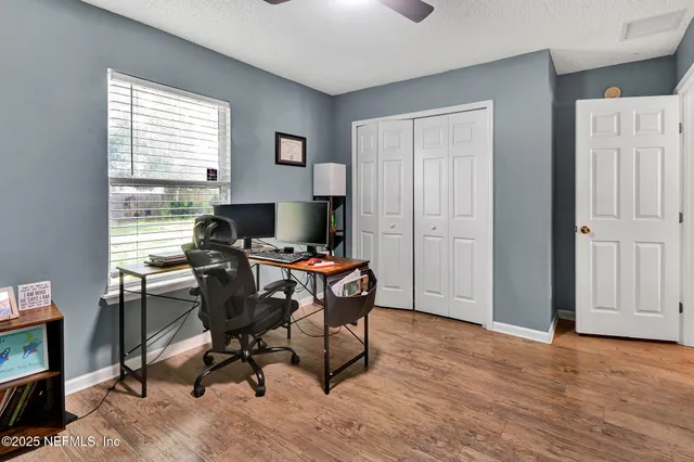 a view of a workspace with furniture and a window