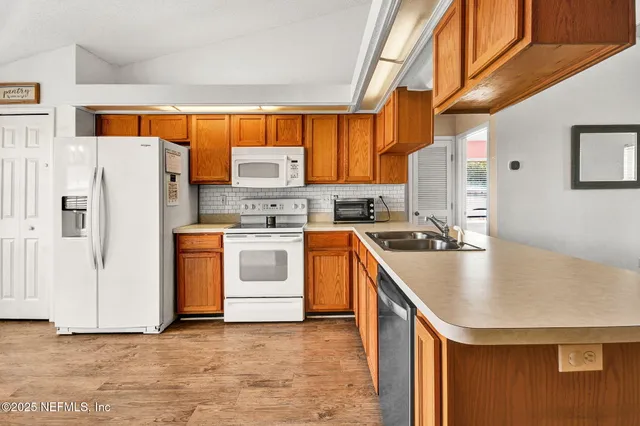 a kitchen with stainless steel appliances a stove a sink dishwasher and a refrigerator