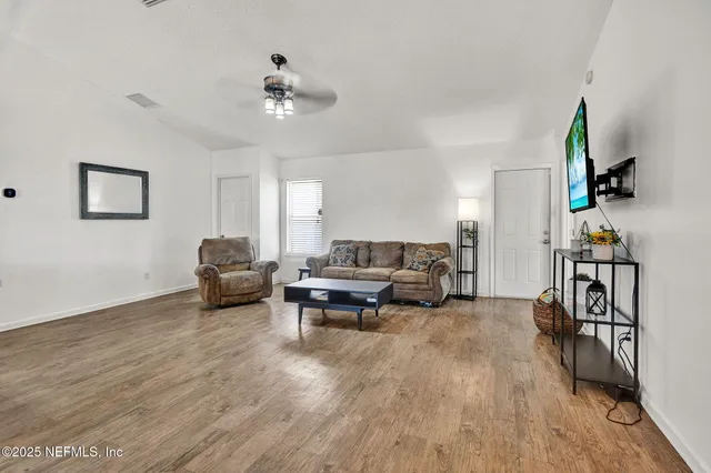 a living room with furniture and a wooden floor