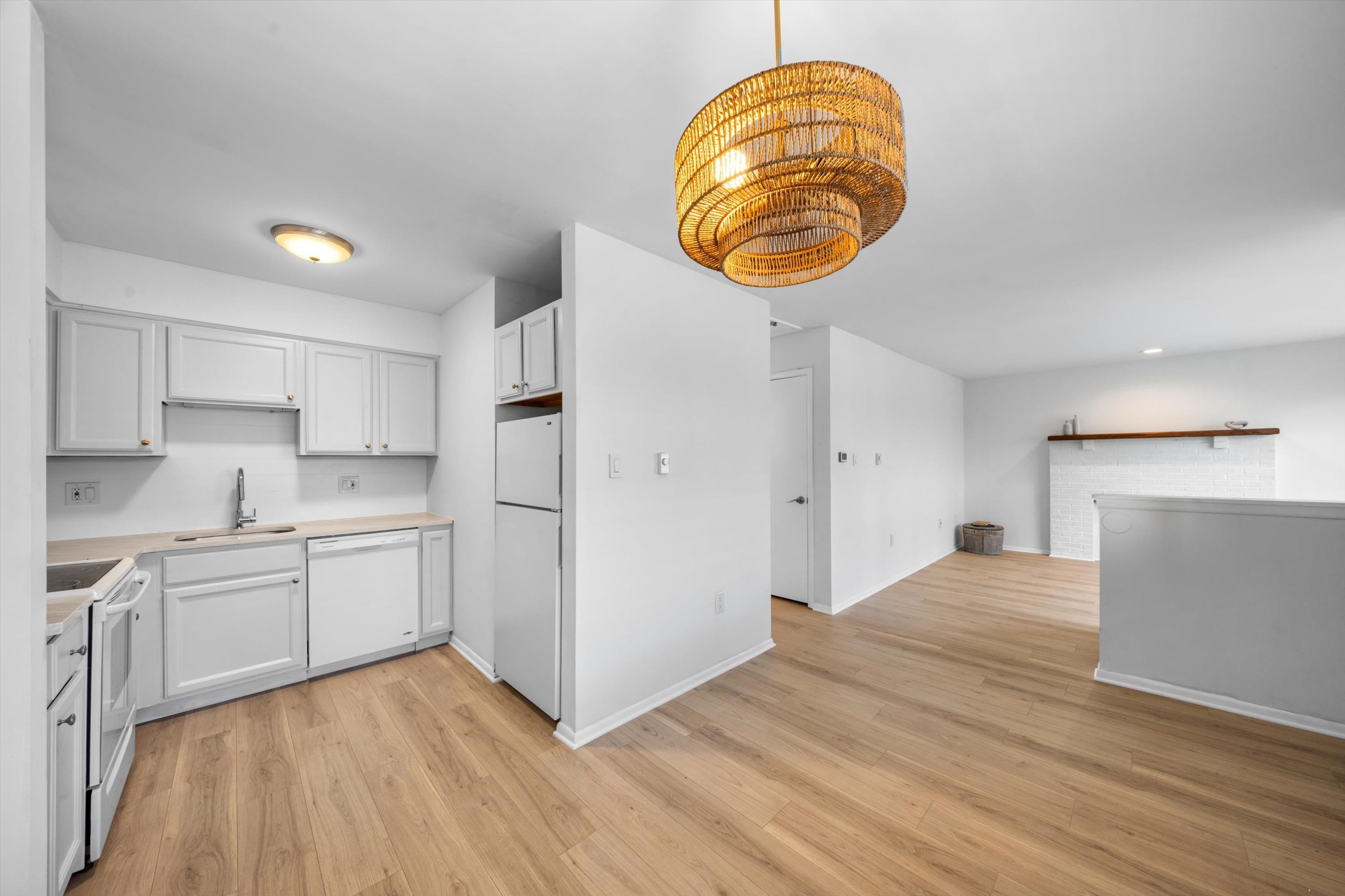 127 40th Street, Unit 1F Sea Isle City, NJ 08243 - Photo 11 of 28 a view of kitchen and empty room with wooden floor