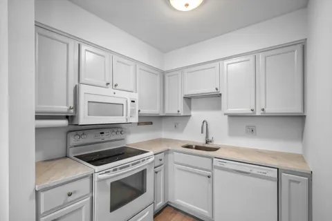 a kitchen with cabinets stainless steel appliances and a sink