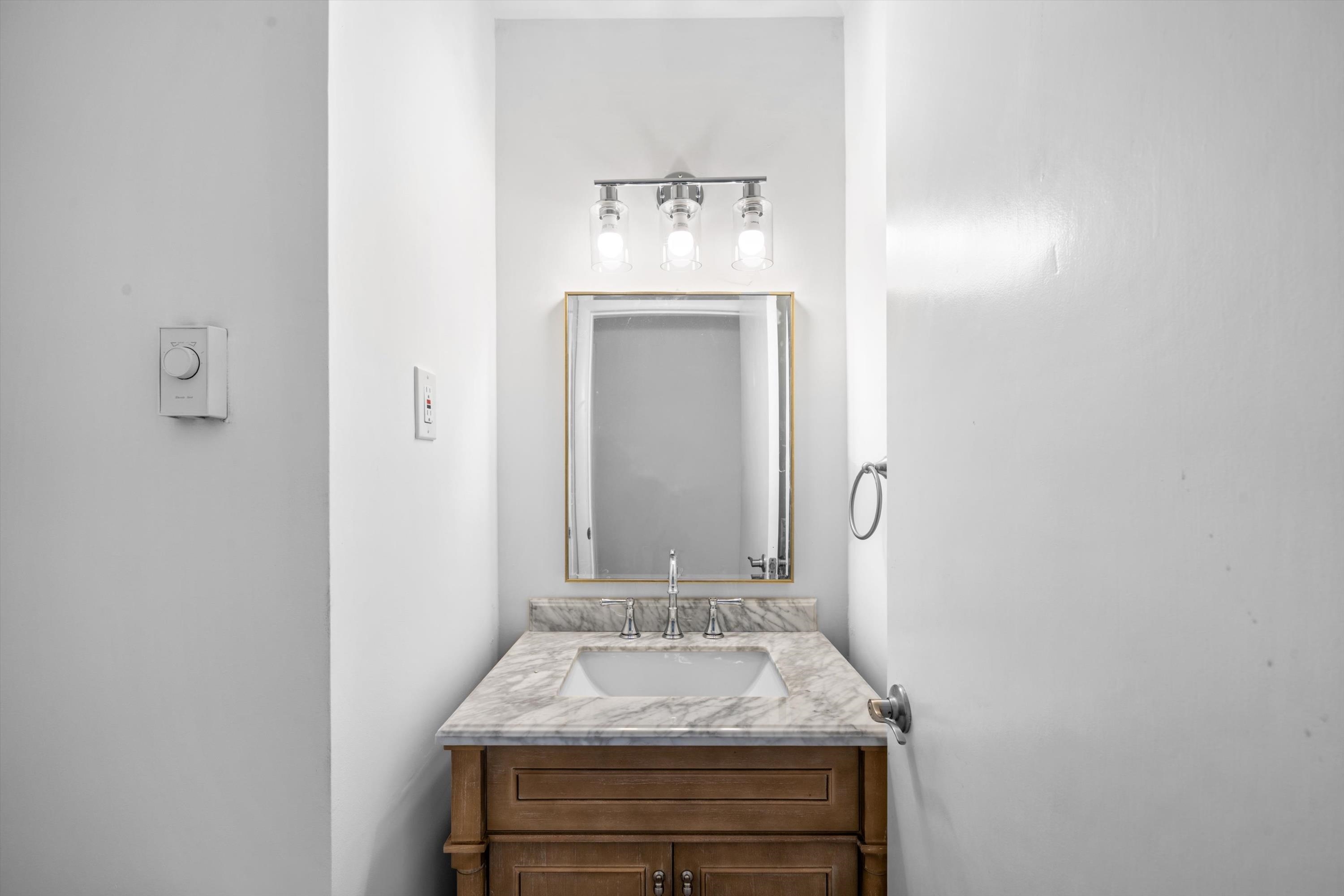 127 40th Street, Unit 1F Sea Isle City, NJ 08243 - Photo 17 of 28 a bathroom with a sink and a mirror