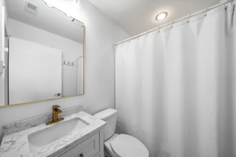 a bathroom with a sink a toilet and shower curtain