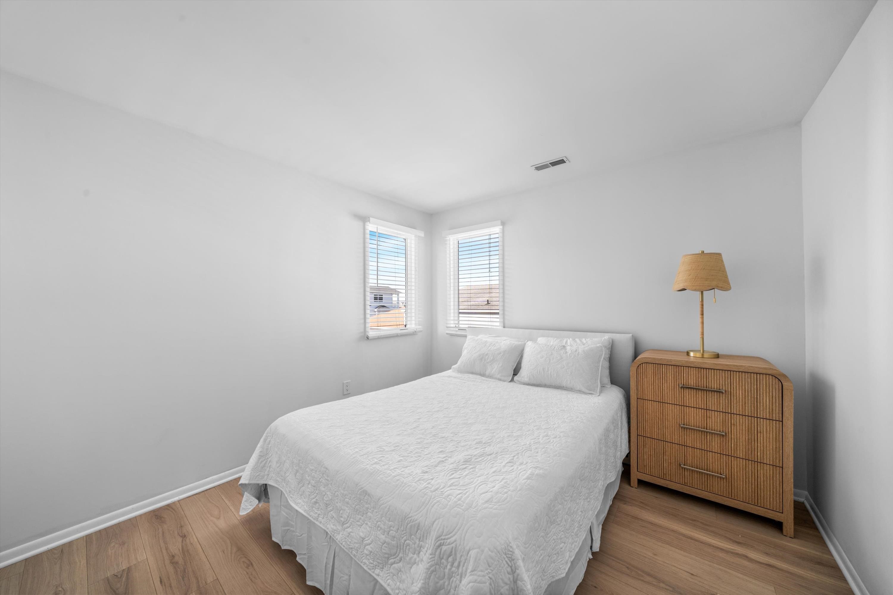 127 40th Street, Unit 1F Sea Isle City, NJ 08243 - Photo 24 of 28 a bedroom with a bed and a night stand