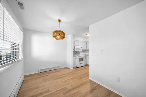 a view of empty room with wooden floor and window