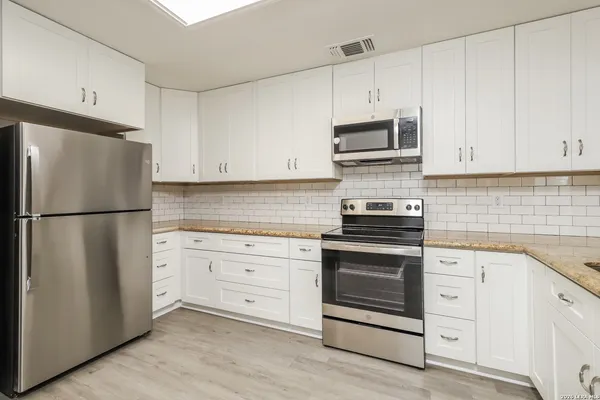 a kitchen with cabinets stainless steel appliances and a sink