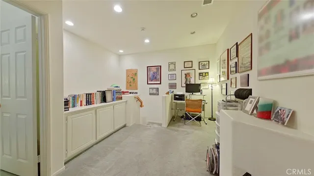 a living room with furniture and a refrigerator