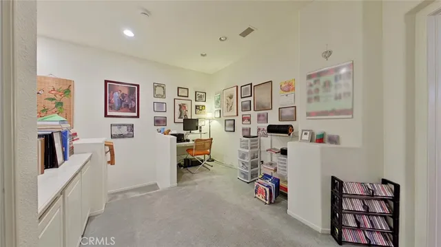 a view of a livingroom with fridge and workspace